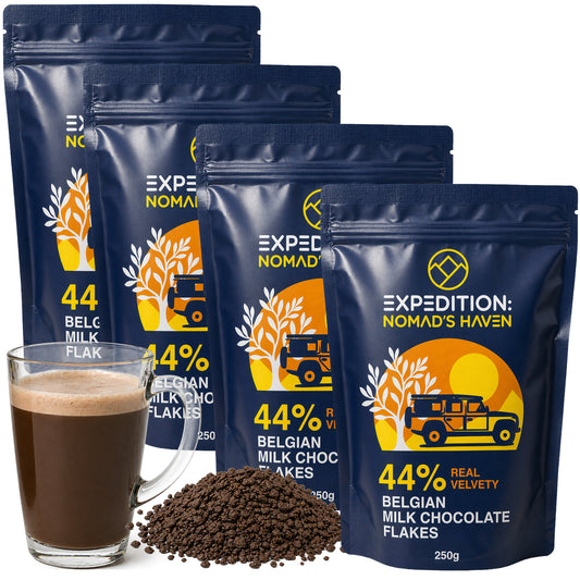 Four 250g pouches of Expedition Nomad's Haven 44% Belgian milk chocolate flakes with a mug of hot chocolate and loose flakes