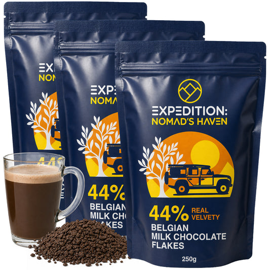 Three 250g pouches of Expedition Nomad's Haven 44% Belgian milk chocolate flakes, 750g total, with a glass mug of hot chocolate