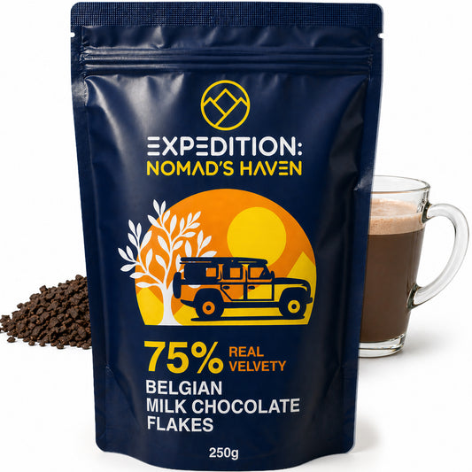 250g resealable pouch of Expedition Nomad's Haven 75% Belgian dark chocolate flakes beside a glass mug of hot chocolate